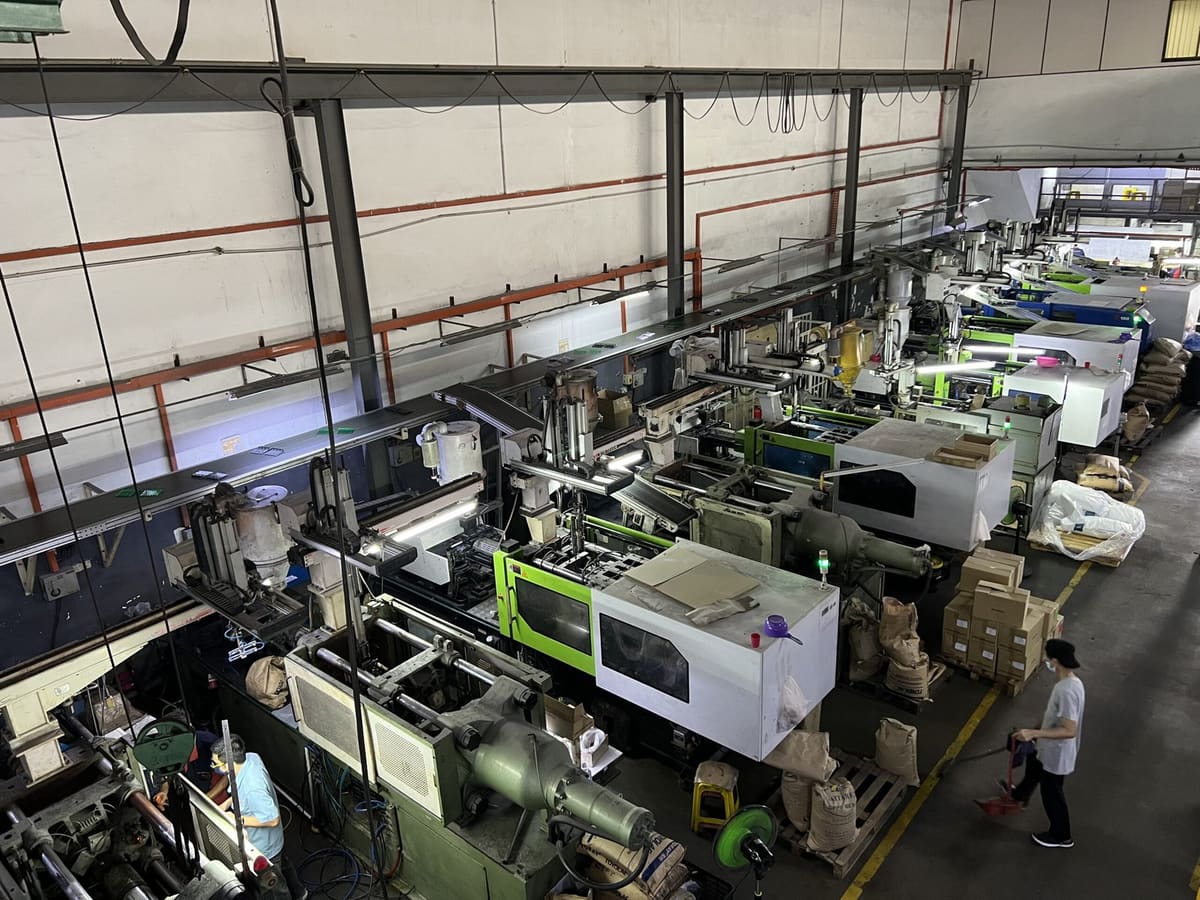 Rows of injection molding machines on the B-PEN Plastic production floor in Klang