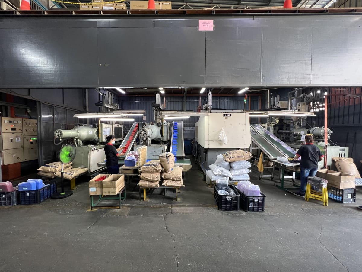 Operators packing freshly molded parts at the press side