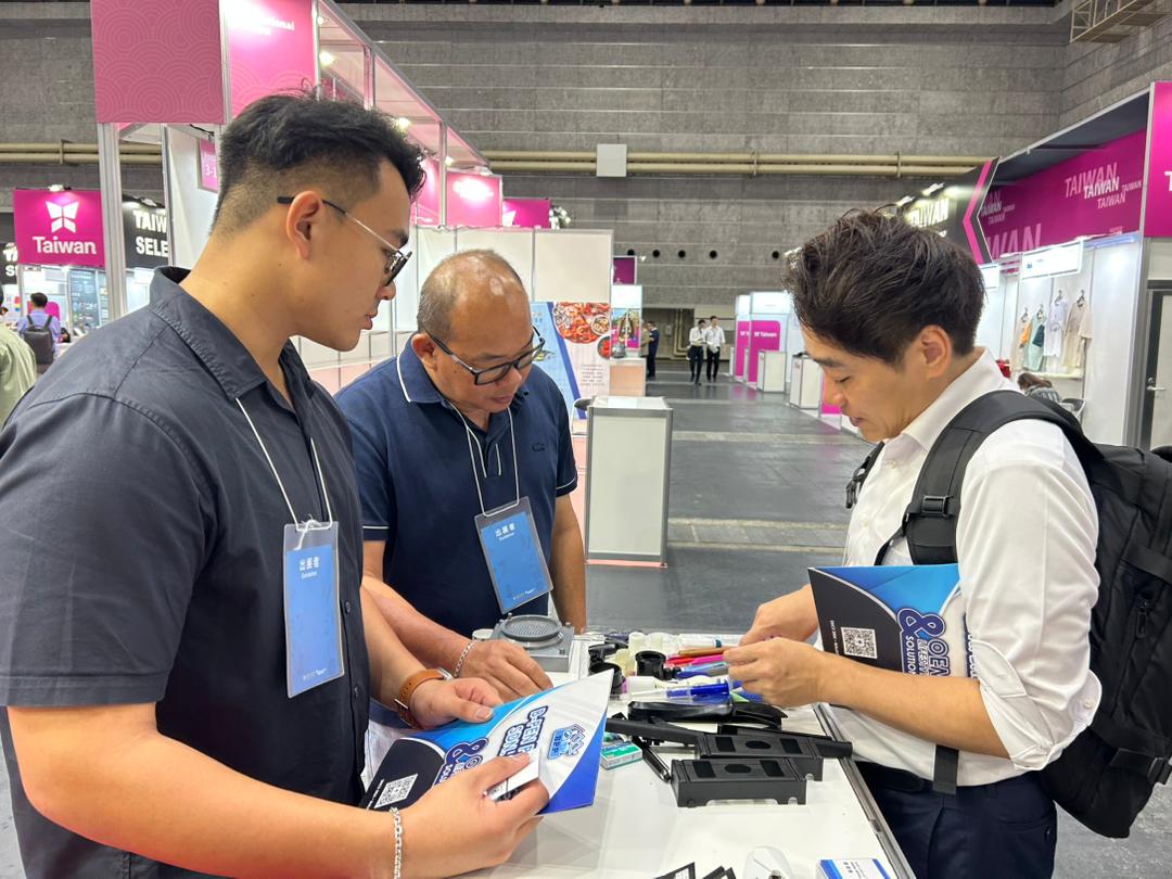 Visitor reviewing injection-molded samples and the company brochure